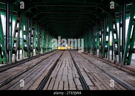 Tramway sur le pont de Gdanski, pont en treillis d'acier traversant la Vistule à Varsovie, Pologne. Banque D'Images