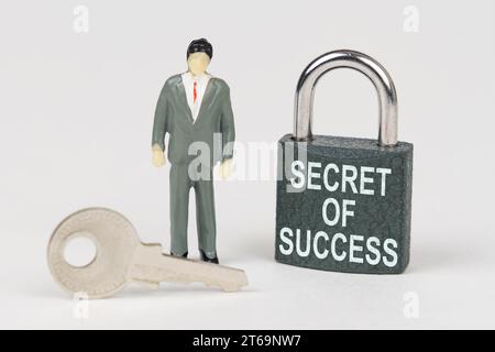 Concept commercial. Sur une surface blanche, il y a une figurine d'un homme d'affaires, une clé et une serrure avec l'inscription - Secret of Success Banque D'Images