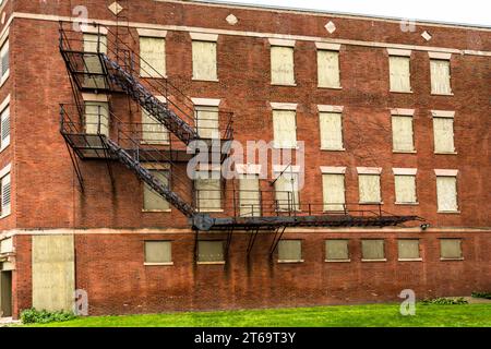L'ancien hôtel Florence à Pullman, Chicago, Illinois, États-Unis, présente une échelle de secours en acier à plusieurs étages longeant des fenêtres condamnées sur son mur arrière en briques. Ouvert en 1881, l'hôtel est resté vide pendant des années, attendant des fonds pour sa rénovation. Le quartier de Pullman à Chicago est en pleine gentrification depuis la fin du XXe siècle. De nombreux résidents participent à la restauration de leurs propres maisons ainsi qu'à des projets dans tout le quartier. Banque D'Images