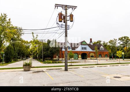 Pylône électrique avec câbles devant les anciennes écuries Pullman, où les chevaux des pompiers étaient logés dans les années 1880 Pôle de puissance avec transformateurs de distribution. Le quartier Pullman de Chicago s'est gentrifié depuis la fin du XXe siècle. De nombreux résidents sont impliqués dans la restauration de leurs propres maisons et dans des projets dans tout le quartier. Chicago, Illinois, États-Unis Banque D'Images