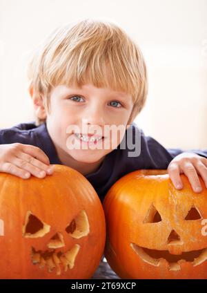 Ses propres Jack-o-Lanterns. Portrait d'un jeune garçon derrière deux jack-o-lanternes. Banque D'Images