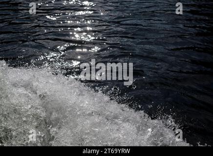 Éclaboussures d'eau de la surface lorsqu'un bateau à moteur glisse sur l'eau Banque D'Images