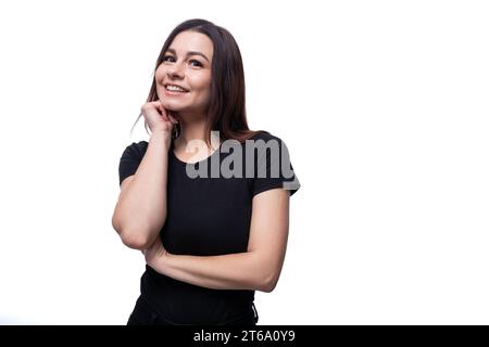 Jeune femme amicale aux cheveux noirs portant un T-shirt noir sur fond blanc avec espace copie Banque D'Images