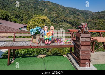 Statue en céramique d'un couple thaïlandais tenant un coeur sur un banc au café Doi Phamee et restaurant dans le quartier Mae Sai de Chiang Rai, Thaïlande Banque D'Images