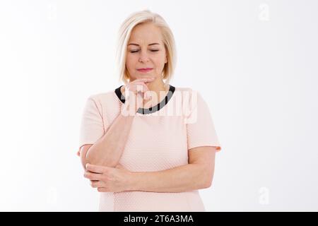 Triste pensive femme d'âge moyen posant sur un fond blanc, concept de santé de ménopause Banque D'Images