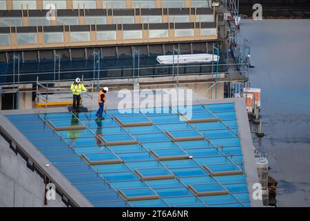 Inspecteur contrôlant la nouvelle fenêtre d'un puits de lumière sur le toit d'un bâtiment commercial. Banque D'Images