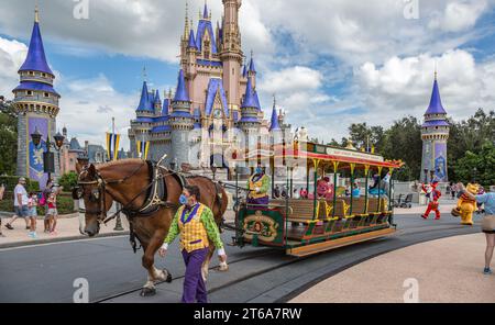 Le cochon monte un chariot tiré par des chevaux devant le château de Cendrillon suivi par Tigger et Winnie l'Ourson sur la rue principale dans le Magic Kindom Banque D'Images