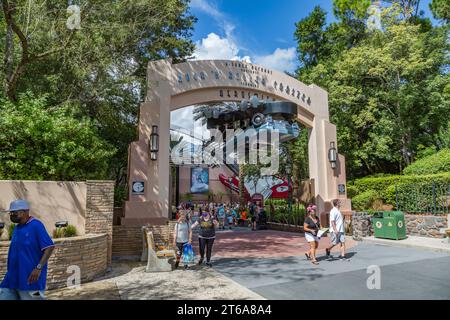 Les clients du parc masqué sortent sous le panneau d'entrée pour le Rock 'n' Roller Coaster Ride au parc thématique Disney's Hollywood Studios Banque D'Images