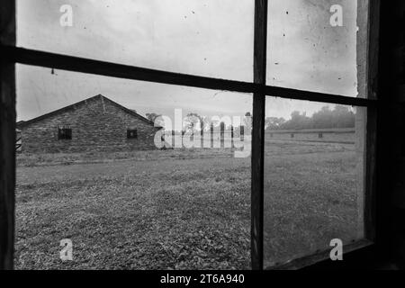 KZ Auschwitz durch ein Fenster sieht man ein gegenueber liegende Steinbaracke in der Frauen und Kinder gemeinsam untergebracht waren. Die Steinbaracken der Frauen und Kinder stehen getrennt von den Holzbaracken der Maenner auf der anderen Seite des Gelaendes. *** Camp de concentration d'Auschwitz par une fenêtre, vous pouvez voir une caserne de pierre en face où les femmes et les enfants étaient logés ensemble la caserne de pierre des femmes et des enfants est séparée de la caserne de bois des hommes de l'autre côté du terrain xMMx crédit : Imago/Alamy Live News Banque D'Images