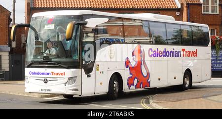 Chauffeur d'autocar au travail à Caledonian Travel voyage vacances tour autocar vue latérale nom de marque et logo Scottish Lion véhicule Mercedes blanc à Wroxham Norfolk Royaume-Uni Banque D'Images