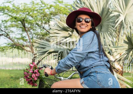 Jeune femme faisant du vélo par une journée ensoleillée. Banque D'Images