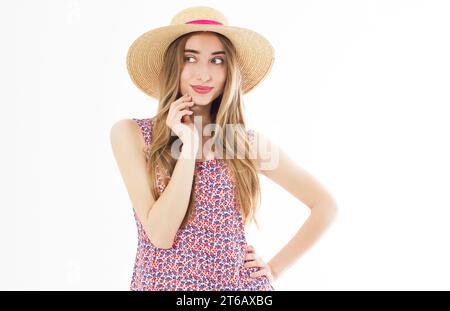 Gros plan portrait de la femme blonde étonnante avec les cheveux ondulant posant sourire mignon. Adorable jeune femme dans le chapeau de paille profitant du vent d'été tout en dépensant t Banque D'Images