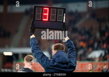 Sideline arbitre montre 4 minutes de temps supplémentaire pendant le match de football. Banque D'Images