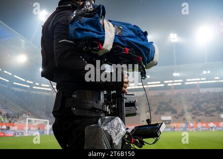 Cameraman derrière le terrain de jeu pendant le match de football sous la pluie Banque D'Images