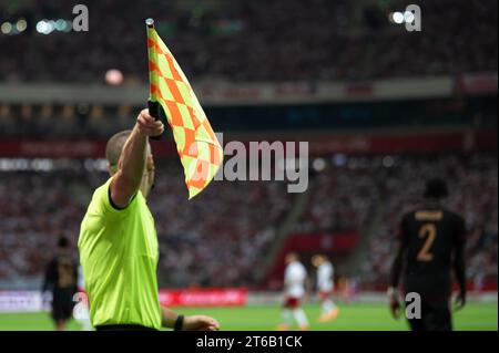 Drapeau levé de l'arbitre latéral pendant un match de football. Banque D'Images