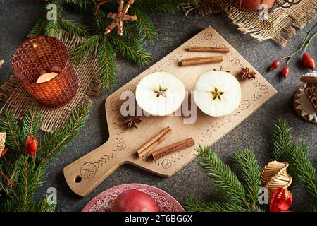 Pomme coupée en deux avec une étoile au milieu avec des branches d'épicéa et décoration de Noël Banque D'Images