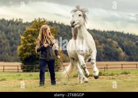 Une jeune femme et son cheval islandais travaillant et câlinant ensemble, concept d'équitation naturelle équestre Banque D'Images