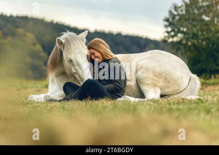 Une jeune femme et son cheval islandais travaillant et câlinant ensemble, concept d'équitation naturelle équestre Banque D'Images