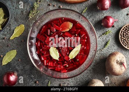 Kvass de betterave rouge fermenté dans un bol en verre avec oignons, Laurier et piment de la vallée Banque D'Images