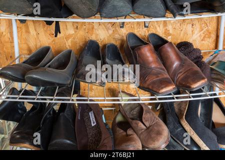 Rack en métal avec chaussures de femme usagées à vendre à l'intérieur du magasin de biens d'occasion et de biens meubles. Banque D'Images