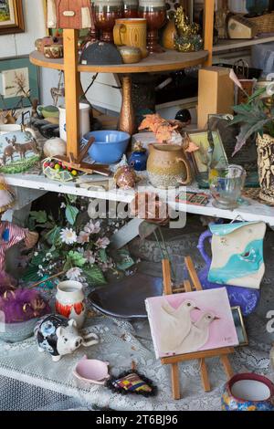 Peinture de colombes blanches, fleurs en soie et curiosités à vendre à l'intérieur du magasin de biens d'occasion et de biens meubles. Banque D'Images