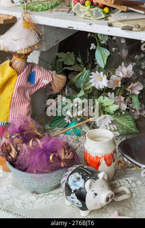 Tirelire en céramique et fleurs en soie à vendre à l'intérieur du magasin de biens d'occasion et de biens meubles. Banque D'Images