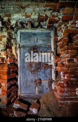 Vieille porte dans une prison abandonnée en ruine. Banque D'Images