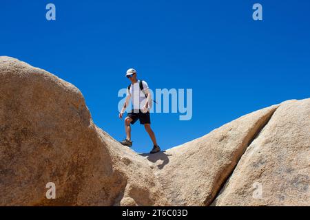 L'homme marche sur le bord du rock.destination et exploration. Arch Rock Trail, parc national de Joshua Tree, Californie, États-Unis Banque D'Images