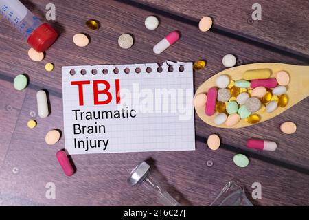 Page de cahier avec texte TRAUMATISME CRÂNIEN, sur une table avec un stéthoscope et un stylo, concept médical Banque D'Images