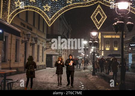 Photo de deux personnes blanc caucasien mâle et femelle, heureux, marchant dans les rues de Belgrade, serbie, tenant des tasses de café et de boire des plats à emporter Banque D'Images