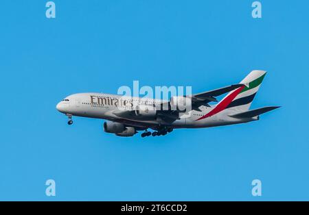 Emirates Airlines Airbus A380 avec les roues vers le bas entrant dans la terre contre un ciel bleu pur. Banque D'Images