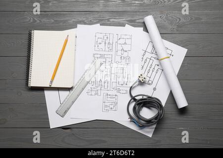 Schémas de câblage, fils et papeterie de bureau sur table en bois gris, mise à plat Banque D'Images
