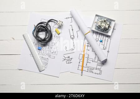Schémas électriques, fils et papeterie de bureau sur table en bois blanc, plat Banque D'Images