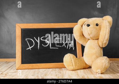 Ours en peluche et petit tableau noir avec mot Dyslexia sur la table en bois Banque D'Images