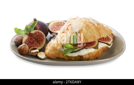 Délicieux croissant avec fromage à la crème, figues et noisettes isolé sur blanc Banque D'Images