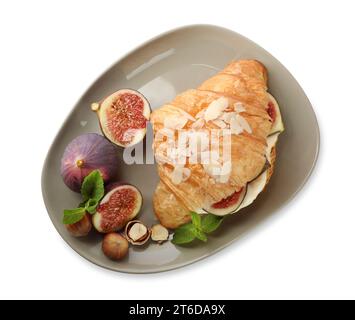 Délicieux croissant avec fromage à la crème, figues et noisettes isolé sur blanc, vue de dessus Banque D'Images