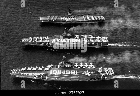 L'USS Independence (CVA-62), l'USS Saratoga (CVA-60) et l'USS Intrepid (CVA-11) sont en cours en 1961, avec des membres d'équipage défilant sur le pont pour commémorer le 50e anniversaire de l'aviation navale américaine Banque D'Images
