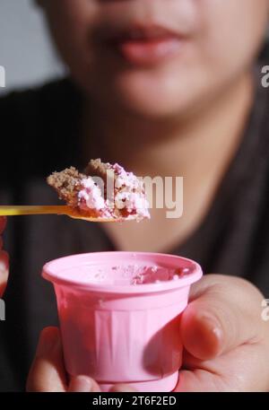 Femme tenant le gâteau de tasse, fond flou doux Banque D'Images
