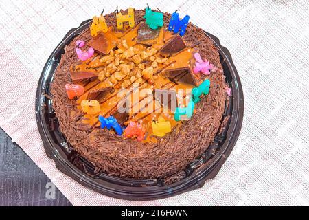 Gâteau au chocolat d'anniversaire festif avec des bougies éteintes sur la table gros plan. Banque D'Images