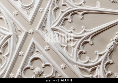 Détails de conception de plafond bas-relief de gypse blanc sur fond beige. Modèle abstrait d'architecture classique, style gothique Banque D'Images