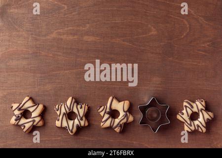 Biscuit en forme d'étoile maison fraîchement cuit avec du chocolat avec des couteaux sur la table en bois avec un espace de copie, bannière horizontale Banque D'Images