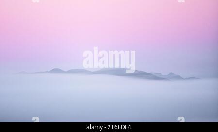 Loch Lomond et le parc national des Trossachs, Écosse, Royaume-Uni. 10 novembre 2023. Météo britannique - un beau lever de soleil atmosphérique sur les Trossachs avec les contours distinctifs de Conic Hill et The Cobbler (Ben Arthur) derrière. Conic Hill se trouve sur la faille Highland Boundary et est une courte promenade populaire sur une colline offrant une vue imprenable sur le Loch Lomond crédit : Kay Roxby / Alamy Live News Banque D'Images