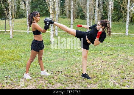 Deux jeunes boxeuses féminines s'entraînant en plein air. Entraînement de boxe et de kick. Banque D'Images