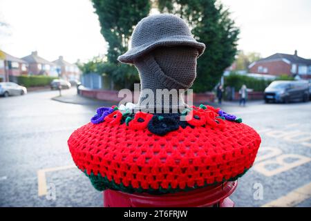 Un surmontoir de boîte aux lettres tricoté pour commémorer le jour de l'armistice est vu à Manchester, Royaume-Uni. Crédit : Jon Super/Alamy Live News. Banque D'Images