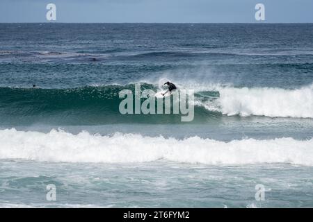 Santa Cruz, États-Unis - 05,02,2023 : Homme avec une combinaison surfant sur une vague sur la côte ouest près de la plage Banque D'Images