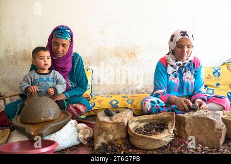 Deux femmes berbères en vêtements traditionnels extraient l'huile d'argan des noyaux de l'Argan Tree Banque D'Images