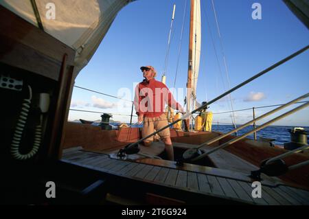 Un homme naviguant dans les Caraïbes sous un ciel ensoleillé. Banque D'Images