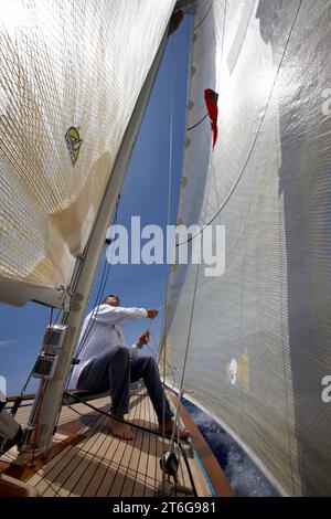 Équipage sur la proue d'un yacht naviguant à Antigua. Banque D'Images