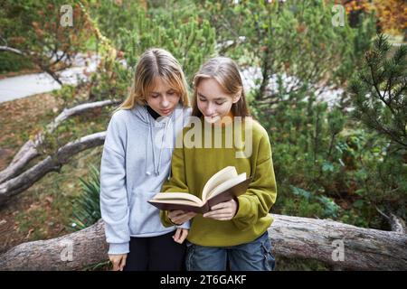 deux jeunes filles lisant un livre dans le parc Banque D'Images