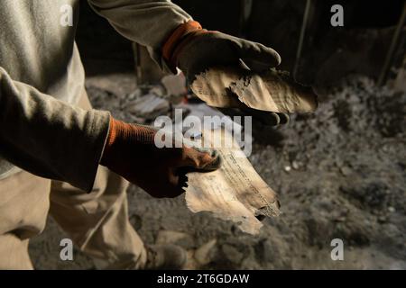 Désert du Néguev, Israël, 09/11/2023, un des archéologues montre les restes d'un livre juif brûlé lors de l'attaque du 7 octobre. Kibboutz NIR Oz, un mois après l'attaque du Hamas : le vide de la destruction, l'odeur de la mort et le travail des archéologues. Un mois après l'attaque du Hamas contre le kibboutz NIR Oz dans le sud d'Israël, le site reste un symbole de la dévastation causée par la violence. L’attaque, qui a eu lieu le 7 octobre 2023, a fait 140 morts, dont 100 habitants du kibboutz. 300 autres résidents ont été blessés. L'attaque a été la plus meurtrière de l'histoire o Banque D'Images